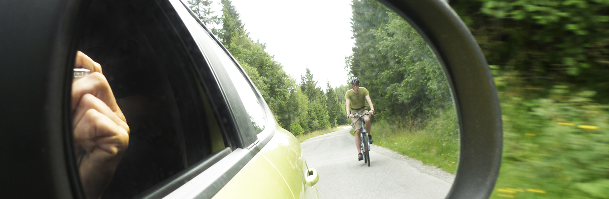 ciclista visto desde el retrovisor de un oche